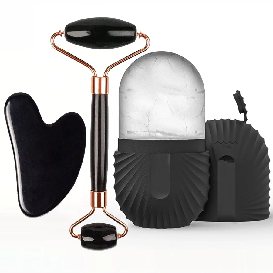Set of facial tools including a roller, gua sha tool, and face massager on a white background